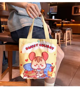 Yellow canvas tote bag with cute cartoon mouse graphic, large capacity commuter bag.