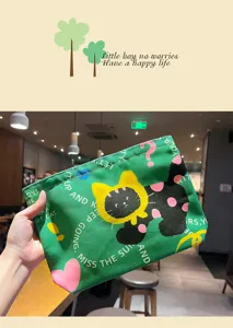 Green canvas toiletry pouch detail, cute cat print zippered makeup bag for travel use.