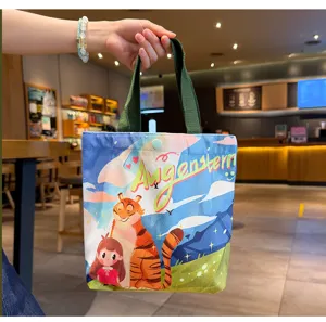 Cute cartoon print canvas tote bag with green handles, casual daily commuter lunch bag.