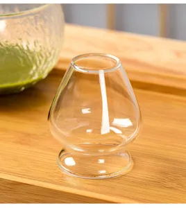 Clear glass matcha whisk holder detail view, elegant tea ceremony tool stand accessory.