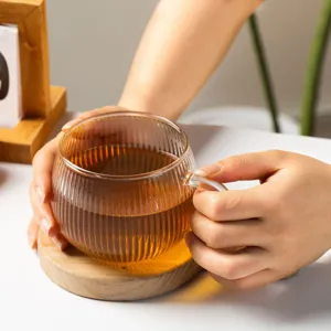 Clear ribbed glass coffee mug pumpkin style with wooden coaster for hot milk tea daily use.