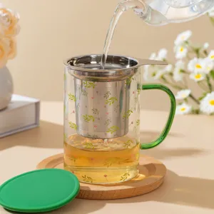 Heat resistant glass tea infuser mug with green handle and infuser basket for office use.