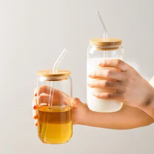 Clear glass tumbler with bamboo lid and glass straw for cold drinks, stylish and durable cup.