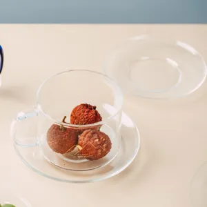 Set tazza e piattino in vetro trasparente con elegante design stampato per cucina.