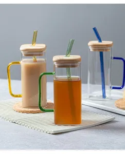 Clear square glass cup with bamboo lid colored handle and glass straw for daily use and home drinks.
