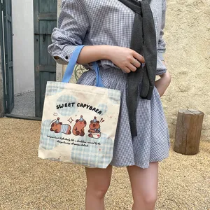 Cute cartoon capybara canvas tote bag for women, stylish large capacity handbag daily use.