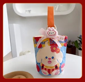 Detailansicht der süßen Canvas-Eimer-Tasche mit Cartoon-Hundemuster, Plüsch-Häschen und Schleife.