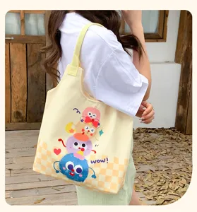 Detailed view of the cute monster cartoon canvas shoulder bag, showing print and fabric texture.