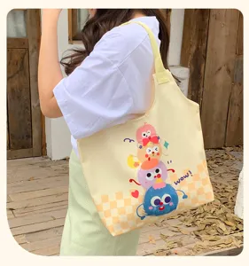 Cute cartoon monster print canvas tote bag, spacious shoulder bag for daily commute.