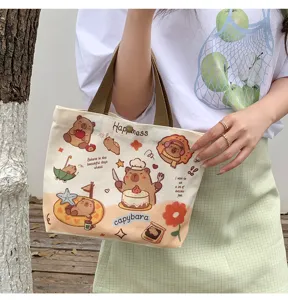 Detail view of the cute capybara canvas tote bag showing cartoon print and sturdy brown handles.