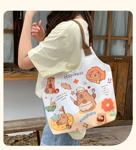 Detail view of cute cartoon capybara canvas tote bag, large capacity shoulder bag for women.
