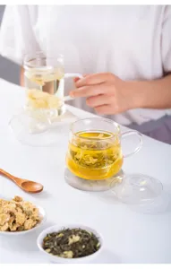 Clear glass tea cup detail showing tea infuser design in a natural lifestyle setting.