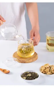 Detail shot of glass tea cup showing transparent material and tea pouring scene for office use.