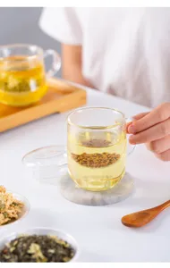 Detail view of the clear glass tea cup featuring a convenient infuser for loose leaf tea.