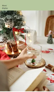 Detail view of the cute 3D Christmas tree glass cup in a cozy holiday scene setup.