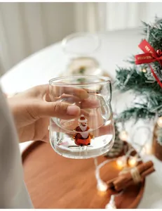 Detail view of clear glass coffee cup with 3D Santa Claus inside for Christmas gift.