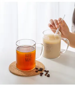 Detail view of clear glass coffee mug with handle and cute morning text design for home.