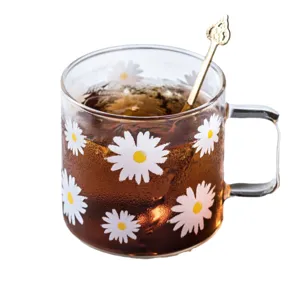 Clear glass mug with cute white daisy patterns, heat-resistant tea cup with handle and spoon.