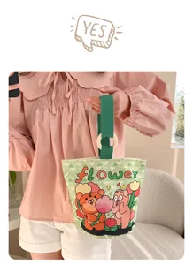 Detailed view of cute green canvas bucket handbag with cartoon animal print and wooden ring.