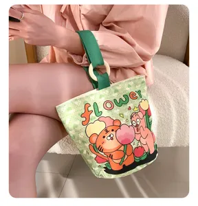 Canvas bucket bag with cute cartoon tiger print, green strap and wooden ring handle for daily use.