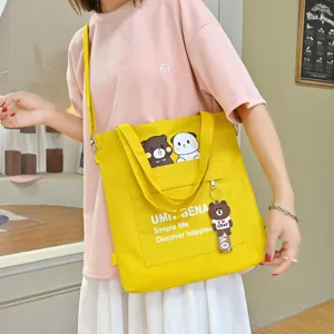 Canvas shoulder bag for women, casual student crossbody tote bag with cute bear pendant.