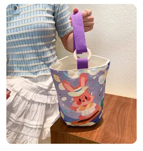 Detailed shot of a stylish canvas bucket bag with purple handle and cute bunny print.