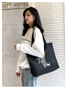 Canvas tote bag detail view showing cartoon girl graphic, casual daily commuting style.