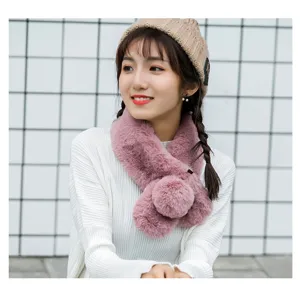 Plush winter scarf detail showing soft pink faux fur texture and cute pom-pom design.