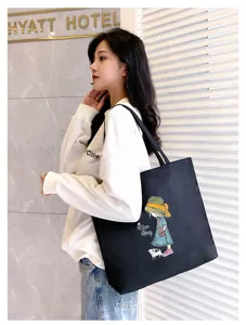 Detail view of black canvas tote bag for women, large capacity shoulder bag with cute print.