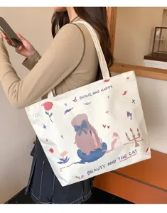 Detail view of casual canvas tote bag with cute cartoon girl print, spacious shoulder design.