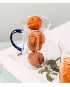 Clear glass cup with blue handle, heat-resistant design for daily coffee or tea drinking.