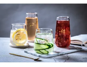 Kreatives transparentes Glas mit goldenen Buchstaben, ideal fuer Saft und Milch im Alltag.