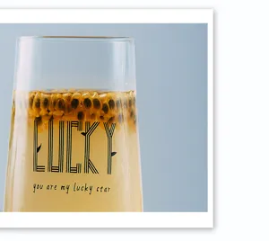 Glass cup detail view, clear heat-resistant glassware with stylish printed text design.