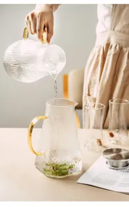 Detail shot of a heat-resistant glass pitcher with a gold handle and hammered texture.
