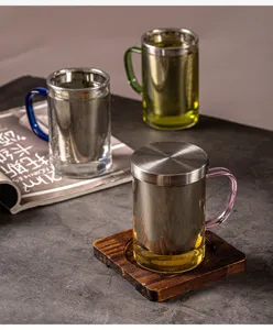 Vue détaillée de la tasse à thé en verre avec infuseur inox et poignée colorée sur table.