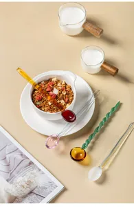 Detailed shot of colorful glass stirring spoons with spiral twist design in a warm tabletop setting.