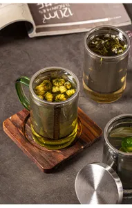 Détail de la tasse infuseur à thé en verre avec filtre en acier inoxydable et support en bois.
