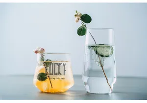 Detail shot of Nordic glass cups set with green plant decor, transparent and heat-resistant.