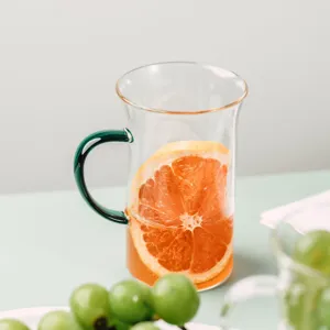 Clear heat-resistant glass water cup with green handle and fruit decor for daily use.