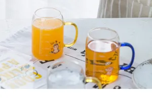 Detailed close-up of a clear glass measuring cup with cartoon print and colored handle.