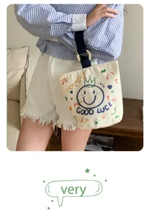 Detail view of casual canvas bucket bag with wooden ring handle and cute printed smiley design.