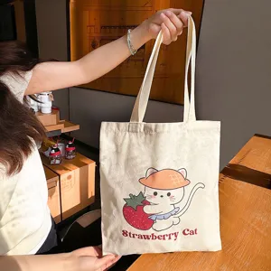 Cute cartoon strawberry cat canvas tote bag for women, large capacity casual shoulder bag for students.