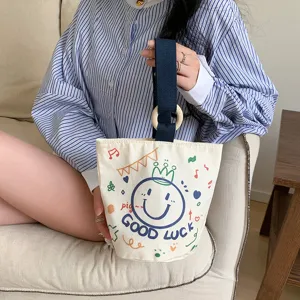 Casual canvas bucket bag for women, stylish handbag with wooden ring handle and cute print.