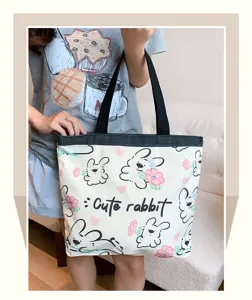 Cute rabbit print canvas tote bag detailed view, casual shoulder bag with black handles and zipper.