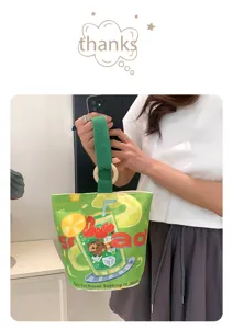 Canvas bucket bag detail view, green strap and wooden ring handle, cute fruit print daily bag.