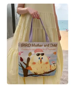 Canvas tote bag detail view, featuring cute bird illustration and purple shoulder straps.