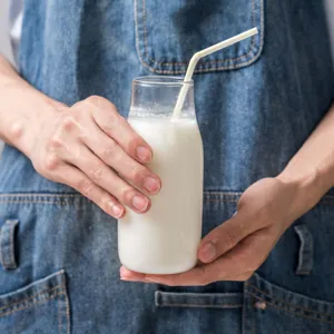 Clear glass milk bottle with straw, elegant cold water juice beverage container for daily use.