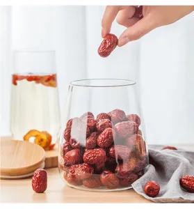 Barattolo di conservazione in vetro trasparente con coperchio in legno per tè e frutta.