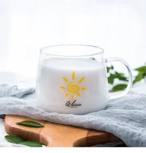 Detail view of transparent heat-resistant glass mug with handle, featuring lovely sun print.