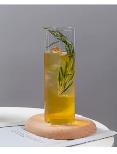 Nahaufnahme eines hohen transparenten Glasbechers mit erfrischendem Getränk und Rosmarin.